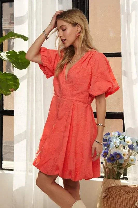 The Coral Blossom DressBright, effortless, and softly romantic, The Coral Blossom Dress features a sculpted mini silhouette with voluminous puff sleeves, a subtle jacquard floral texture, Mini DressesThe Coral Blossom Dress