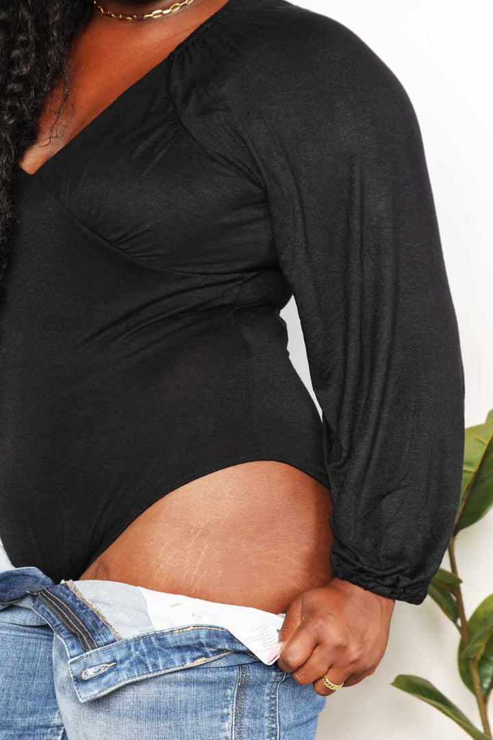 V- Neck Long Sleeve BodysuitThis bodysuit seamlessly merges romantic allure with contemporary flair. The poet sleeves, with their billowing and slightly puffed structure, infuse a sense of dramBodysuitsV- Neck Long Sleeve Bodysuit