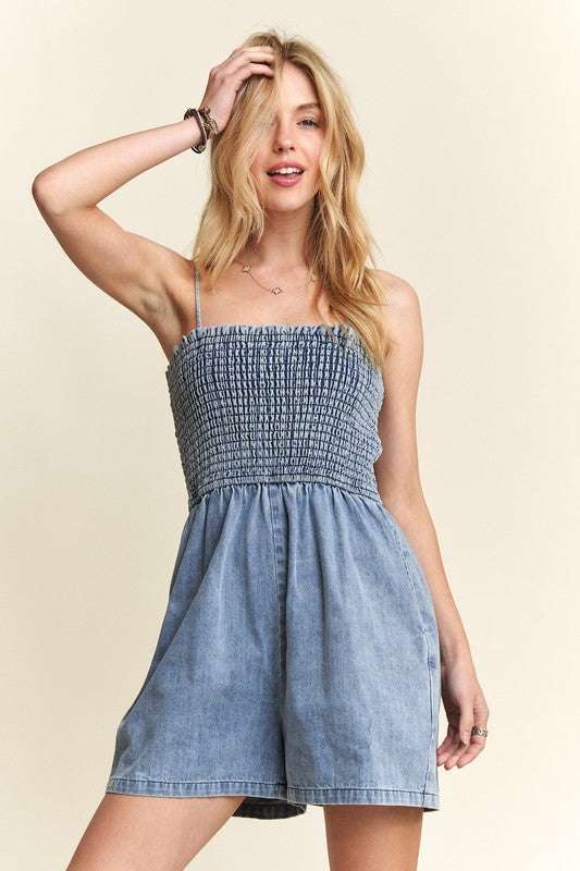 Smocked Spaghetti Strap Denim RomperA smocked spaghetti strap denim romper is a trendy and versatile one-piece 100% cotton outfit that features a smocked bodice, thin spaghetti straps, and denim fabricRompersSmocked Spaghetti Strap