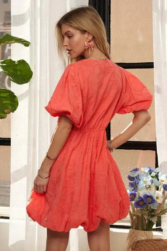 The Coral Blossom DressBright, effortless, and softly romantic, The Coral Blossom Dress features a sculpted mini silhouette with voluminous puff sleeves, a subtle jacquard floral texture, Mini DressesThe Coral Blossom Dress