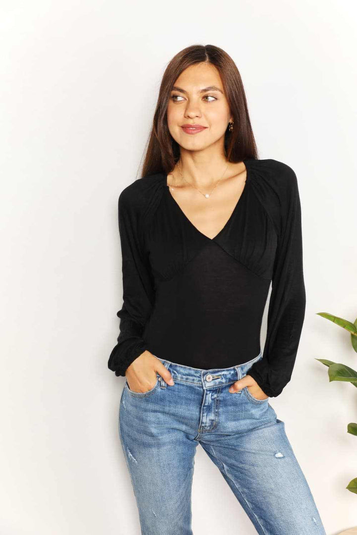 V- Neck Long Sleeve BodysuitThis bodysuit seamlessly merges romantic allure with contemporary flair. The poet sleeves, with their billowing and slightly puffed structure, infuse a sense of dramBodysuitsV- Neck Long Sleeve Bodysuit