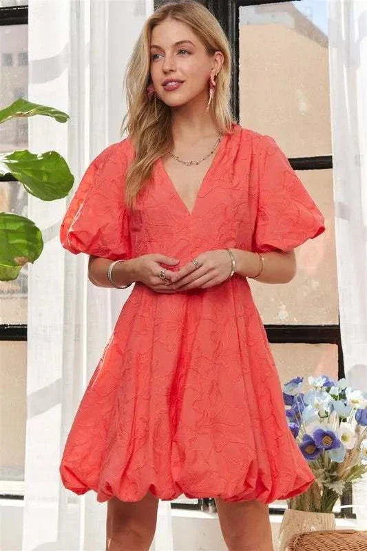 The Coral Blossom DressBright, effortless, and softly romantic, The Coral Blossom Dress features a sculpted mini silhouette with voluminous puff sleeves, a subtle jacquard floral texture, Mini DressesThe Coral Blossom Dress