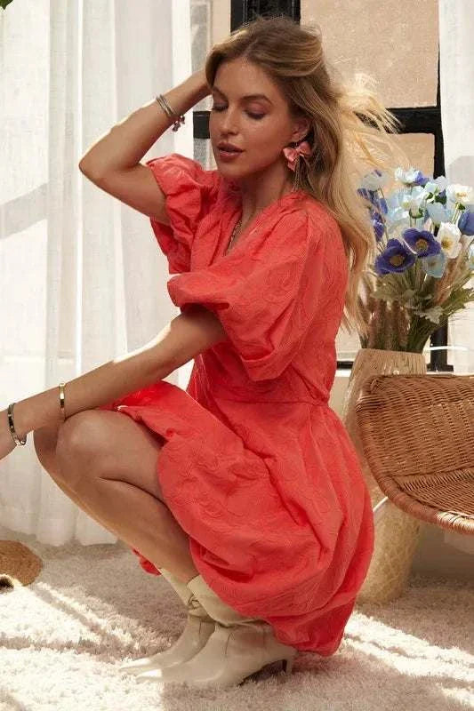 The Coral Blossom DressBright, effortless, and softly romantic, The Coral Blossom Dress features a sculpted mini silhouette with voluminous puff sleeves, a subtle jacquard floral texture, Mini DressesThe Coral Blossom Dress